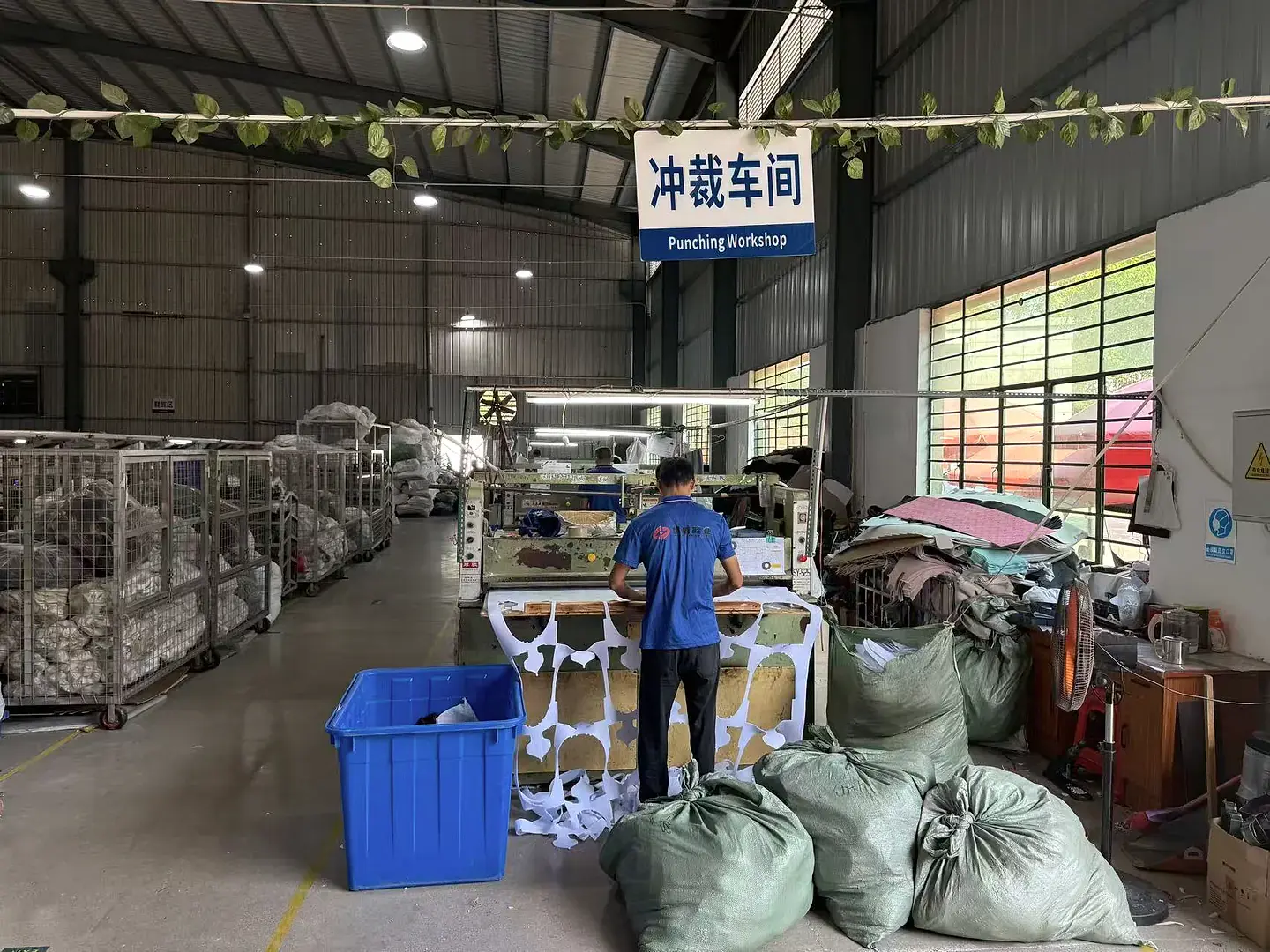 员工操作设备进行鞋材冲裁的车间全景